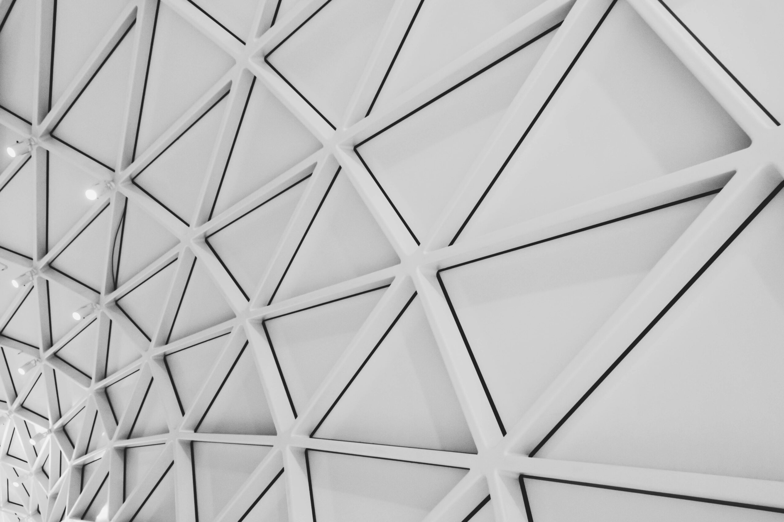 An intricate ceiling design featuring modern geometric patterns and steel structures in a low angle shot.